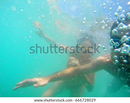 Underwater photo of a young couple diving in the sea