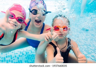 Underwater photo of young friends in swimming pool