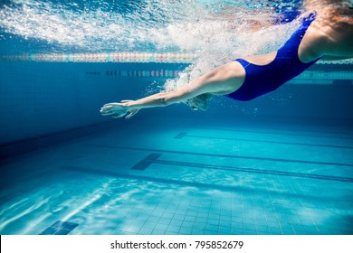 underwater picture of young female swimmer exercising in swimming pool - Powered by Shutterstock