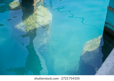 Underwater pier structures and light reflections in crystal clear turquoise water at Limassol Marina
