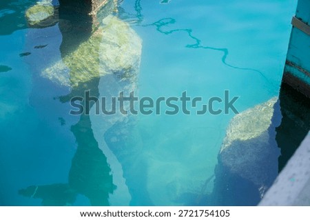 Underwater pier structures and light reflections in crystal clear turquoise water at Limassol Marina
