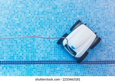 Underwater pool vacuum cleaner. Robotic cleaning of the pool floor. Pool cleaner robot Pool maintenance with automatic robot. Cleaning the bottom  and walls with a submersible robot.  - Shutterstock ID 2233463181