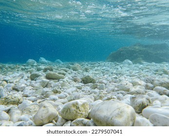 UNDERWATER sea level photo. Turquoise crystal clear water, pebbles of Antisamos beach, Kefalonia island, Ionian sea, Greece. Horizontal. - Shutterstock ID 2279507041
