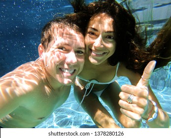 Underwater selfie with of young happy and smiling couple swimming and enjoying  underwater view. - Powered by Shutterstock