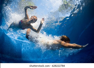 Underwater shot of couple jumping in the pool - Powered by Shutterstock