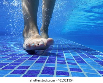Underwater shot of feet walking on the bottom of a pool