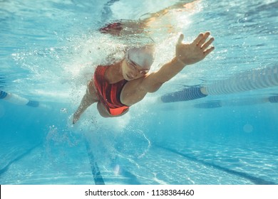 Underwater shot of female athlete swimming in pool. Young woman swimming the front crawl in a pool. - Shutterstock ID 1138384460