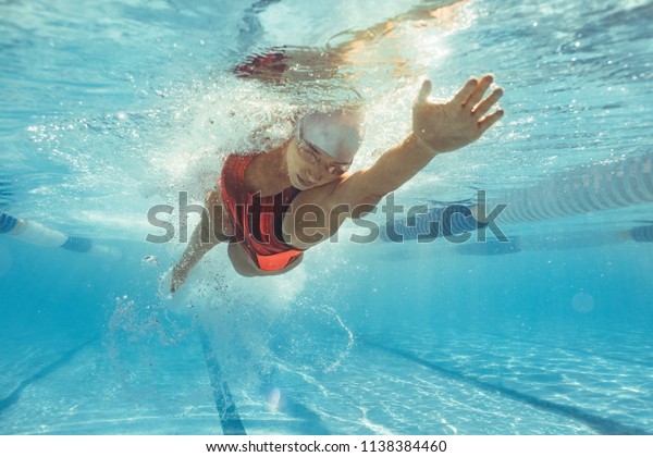 プールで泳ぐ女性の水中撮影 プールの中で前を泳いでいる若い女性 の写真素材 今すぐ編集