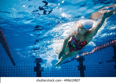 Underwater shot of fit swimmer training in the pool. Female swimmer inside swimming pool. - Powered by Shutterstock