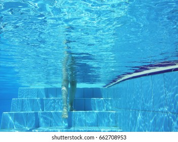 Underwater shot of legs walking stepping on a pool stairs - Powered by Shutterstock