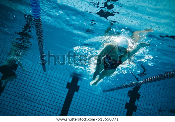 Underwater shot of young female\
swimmer swimming in pool. Young female swimmer training in the\
pool.