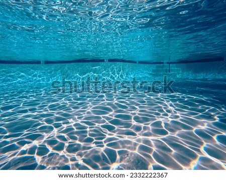 Underwater sunlight patterns in large clean swimming pool.