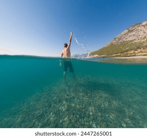 Underwater and surface split view in tropics paradise with happy man, under and above waterline, beautiful view on tropical sea. Turkey . snorkeling vacation concept