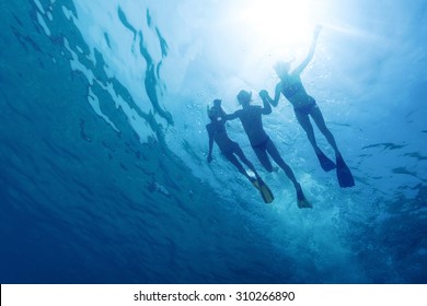 Underwater View Of Friends Snorkeling In The Tropical Sea