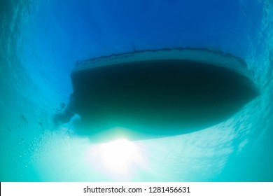 Underwater view looking up at the bottom of a boat hull through the clear emerald colored waters of Florida Bay.