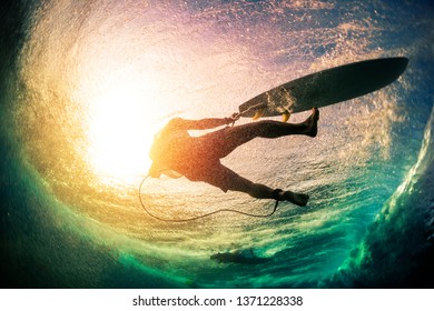 Unterwasseransicht des männlichen Surfers, nachdem er ins Wasser gefallen ist