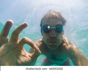 Underwater view of man swimming in the sea - Powered by Shutterstock