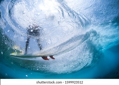 Underwater view of the surfer riding the wave