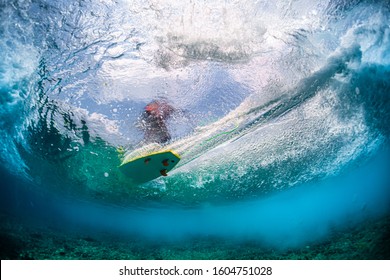 Underwater view of the surfer riding the wave