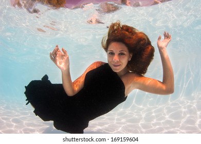 Underwater Woman Fashion Portrait With Black Dress In Swimming Pool. 