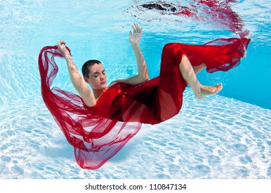 Underwater woman fashion portrait with red veil in swimming pool. - Powered by Shutterstock