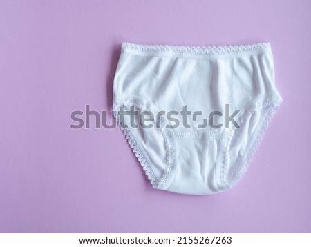 Underwear for children. White panties for girls on purple, knitted cotton underwear. Underwear for children.