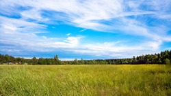An Undeveloped Field And A Sunny Sky With Clouds. Rural Landscape