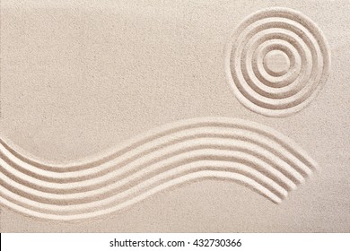 Undulating flowing wave pattern and concentric circles raked in the sand in a traditional Japanese zen garden for wellness and tranquility with copy space