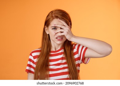 Uneasy redhead girl pity for bad situation, trying not look awful friend wound, cringe aversion, dislike watch horror stories, feel disgust upset, standing uncomfortable clench teeth dislike - Shutterstock ID 2096902768