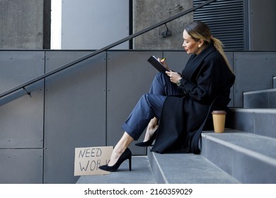 Unemployed Business Woman Sits On The Stairs Near The Building And Fills Resume