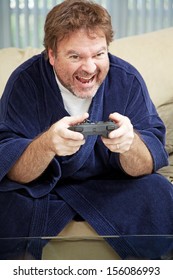 Unemployed Man At Home In His Bathrobe Plays Video Games All Day.  