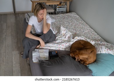 Unemployed Mature Woman Regrets About Difficult Money Problems And Looks Upset. Middle-aged Female Has Absence Of Life Sense But Tries To Think About Life Upgrading Sitting On Bed With Sleeping Dog