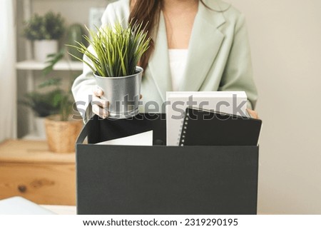 Unemployed, quite job. Desperate asian young businesswoman resigning from company, hand holding stuffs into the cardboard, packing belongings, layoff or changing work. Resignation,employment concept.