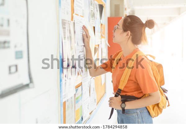 Unemployed young university woman looking\
for work or job after graduation at the post\
board