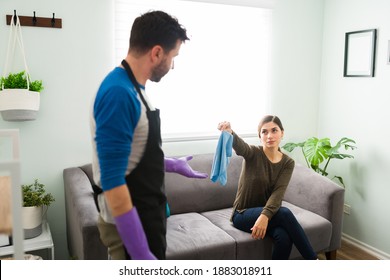 Unequal Relationship. Woman Makes Boyfriend Do All The House Work By Himself And Hands Him Over A Cleaning Cloth