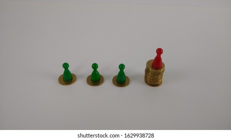 Unequal Wealth Distribution -Coins Were Stacked. The Figure With The Highest Value Has A Different Color 