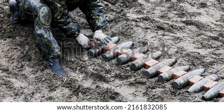 Unexploded shells lying on the ground. Clearing of unexploded ordnance after a battle in a war, undermining.
