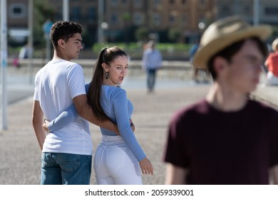 Unfaithful Teenager Girl Walking With Boyfriend And Looking To Another Boy. Disloyalty Concept.