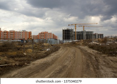 Unfinished building construction against already built houses. View from far. Building concept