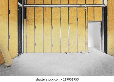 Unfinished building interior, walls covered with rock-wool.