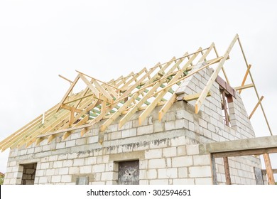 Unfinished House In Countryside. Part Of House With Wooden Construction Of Roof. Building A House In European Village (in Poland). Small Family House At Construction.