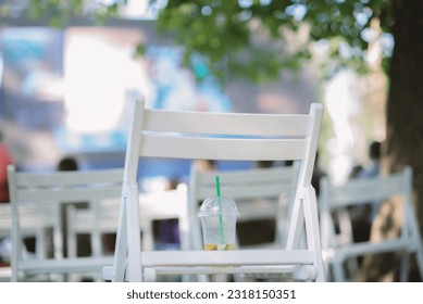 An unfinished lemonade stands on a chair in a summer cinema - Powered by Shutterstock