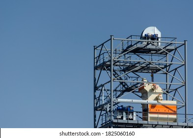 The Unfinished Metal Structure Of The Bucket Elevator Against The Sky. Construction Of A Modern Grain Elevator. Grain Transportation And Storage Technology.