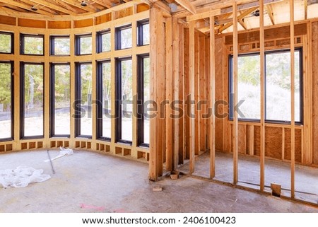An unfinished residential home under construction with wood framing beam supporting it