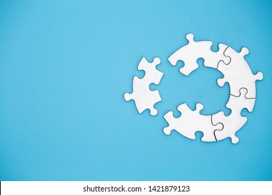 Unfinished white jigsaw puzzle pieces on blue background, The last piece of jigsaw puzzle, Copy space.