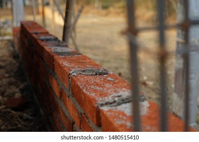 Unfinished yet red brick wall still on progress under construction