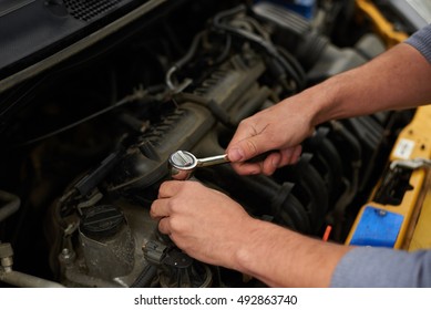 Unfix Ignition Coils. Mechanic With Wrench In Hands