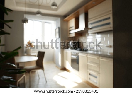 Unfocused background of modern kitchen interior with table and sunlight window.