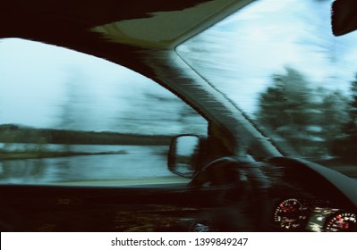 Unfocused blurred view through the moving car windscreen inside the car interior. Glitch retro effect.
