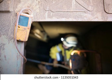 Unfocused, Blurry Picture Of Rope Access Miner Working Inside The Confined Space While Yellow Gas Test Detector Atmosphere Is Hanging On The Entry Manhole Construction Mine Site Perth, Australia  